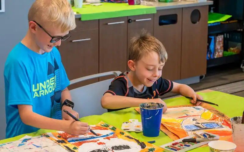Smiling children working on a craft activity at a colorful table