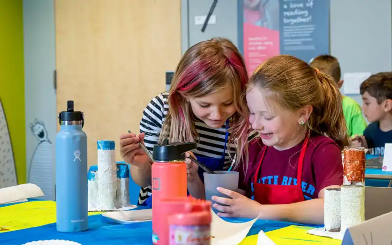 Friends working together on a craft project with art supplies