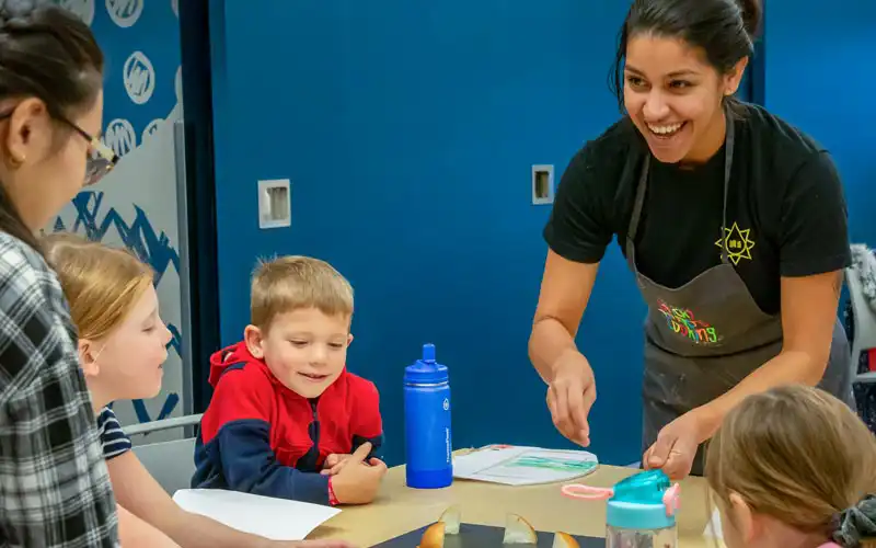 Volunteers assisting children with hands-on learning activities