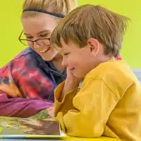 Teen volunteer reading with a child